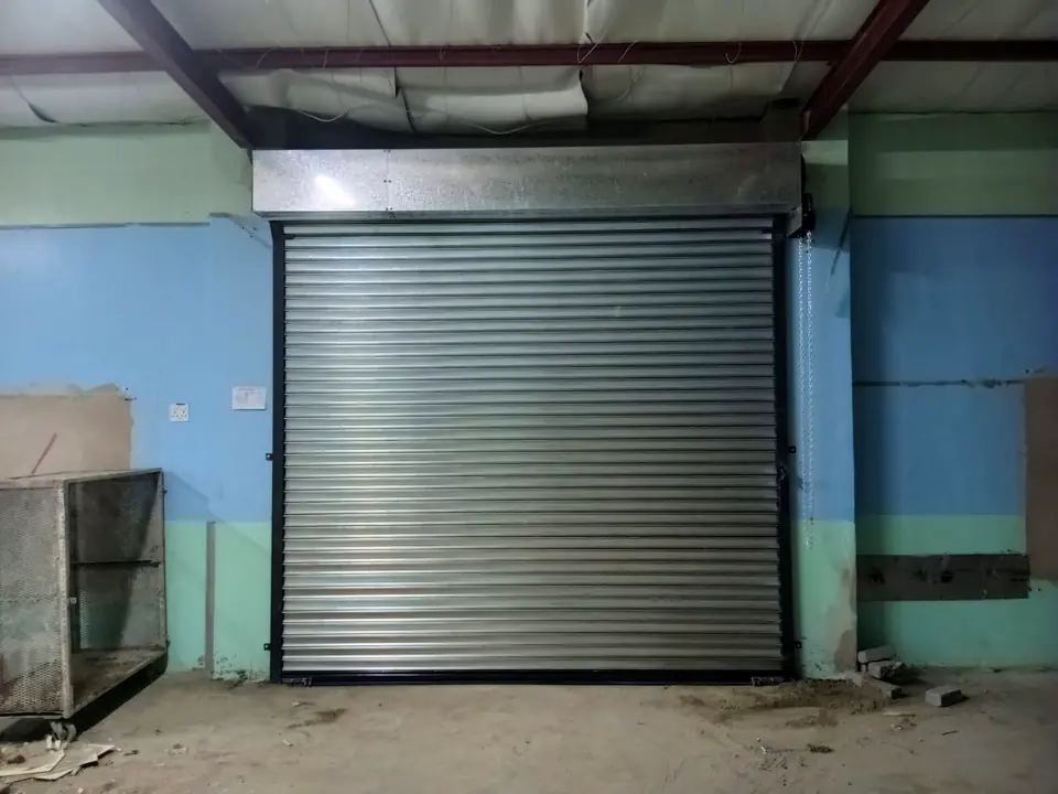 Galvanised roller door in a factory with blue walls