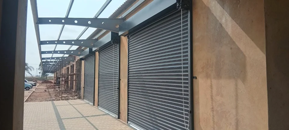 Row of charcoal roller shutter doors installed along a covered walkway