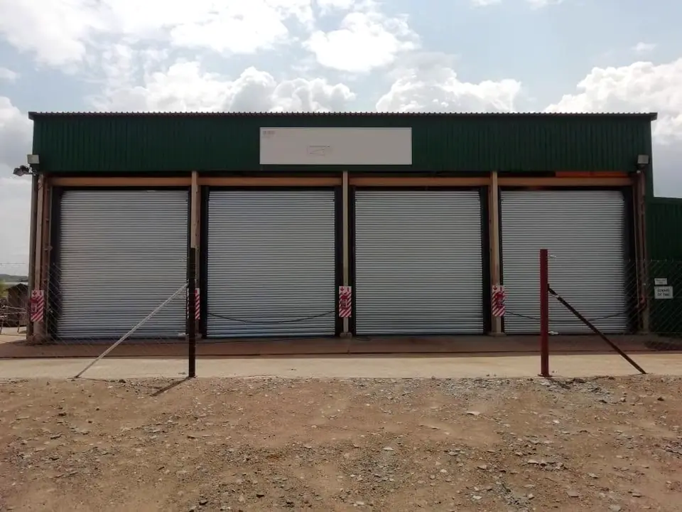 Four galvanised roller shutter doors on a steel-framed shed