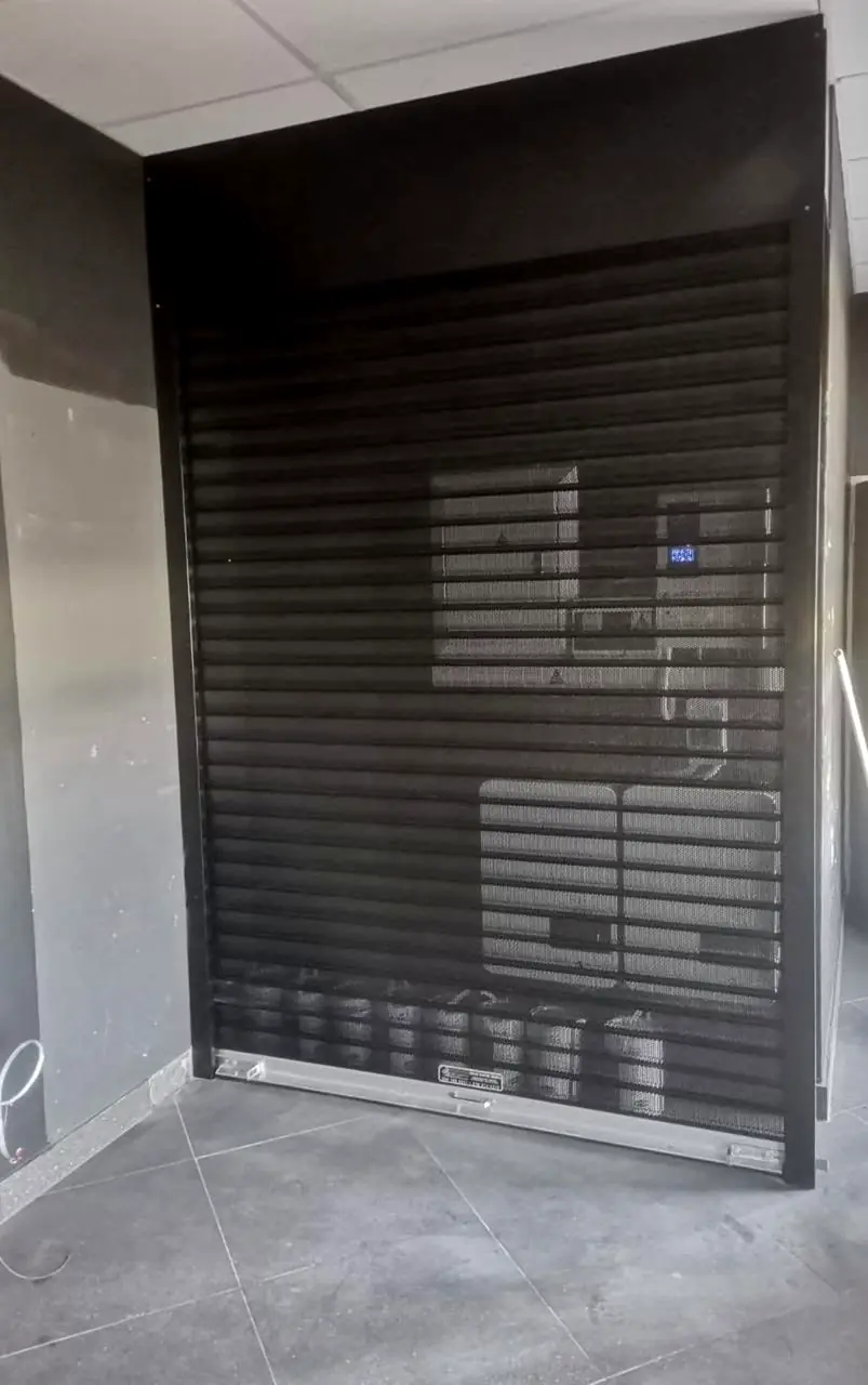 Black perforated security roller shutter on a shopfront