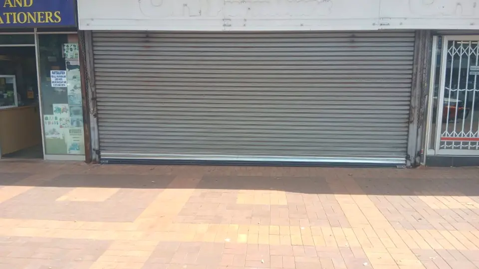 Shopfront roller shutter on a paved walkway